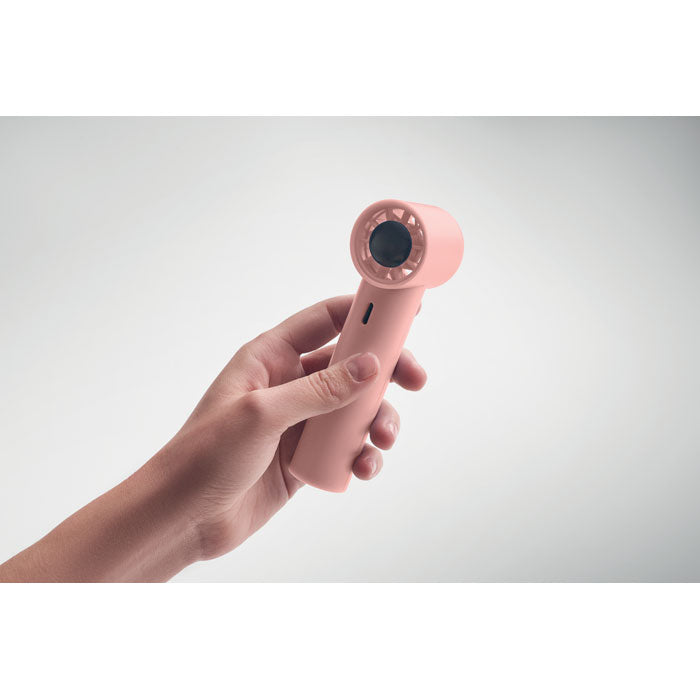 Hand holding a pink hair dryer against a light gray background