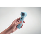 Hand holding a light blue handheld device against a gray background