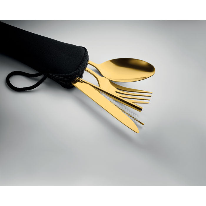 Gold cutlery set with black pouch on a gray background