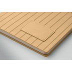 Beige leather-bound notebook with a textured cover on a light gray background