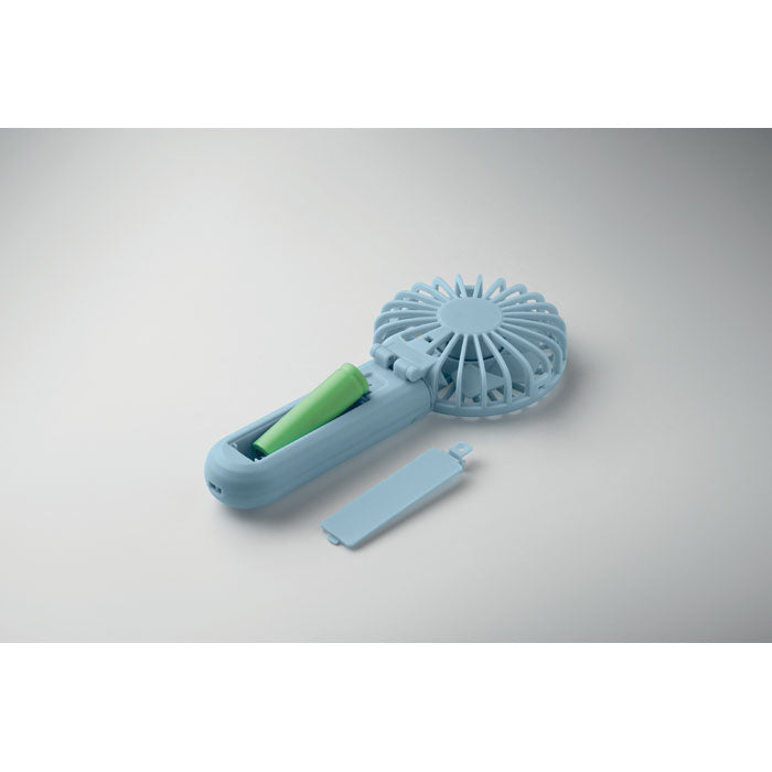 Blue handheld fan with a green handle on a gray background