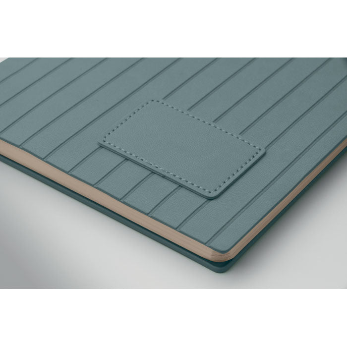 Teal textured notebook with a pocket on a white background