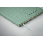 Green notebook with a textured cover on a light gray background