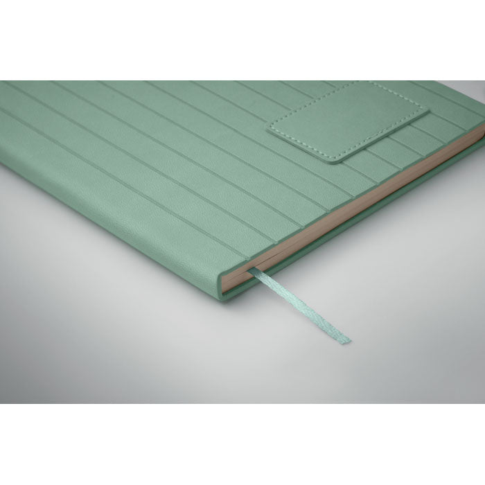 Green notebook with a textured cover on a light gray background