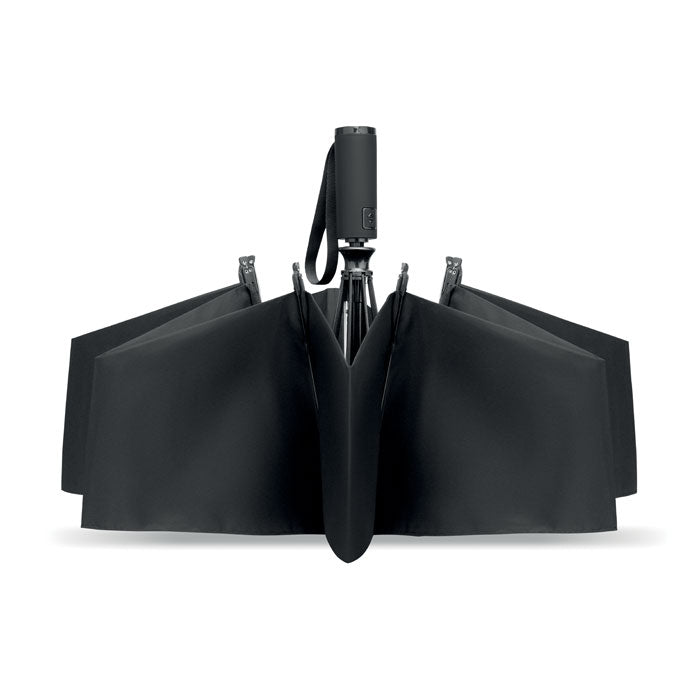Black umbrella folded and standing on a white background